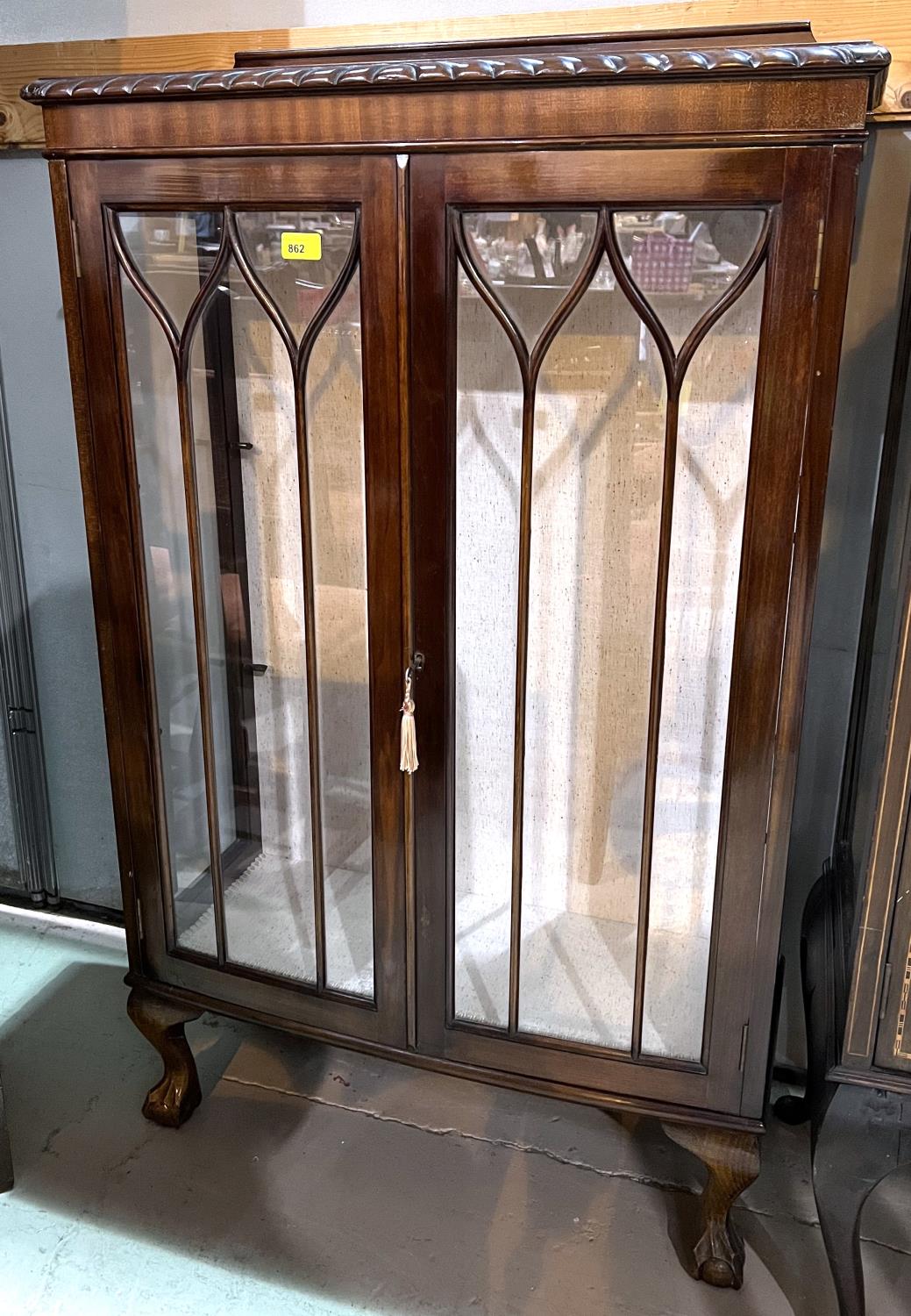 An early 20th century mahogany display cabinet with 2 glazed doors, on ball and claw feet