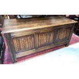 A reproduction oak Priory blanket box having front panels with linen fold decoration