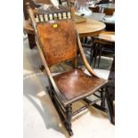 A stained wood rocking chair with decoration to back