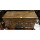 An 18th century style oak blanket box with arched carved panels to the front