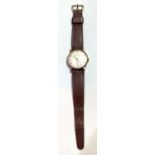 A gents vintage 9 carat Garrard wristwatch, on brown leather strap, inscribed