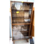 A 1950's full height bookcase enclosed by 2 pairs of glazed sliding doors