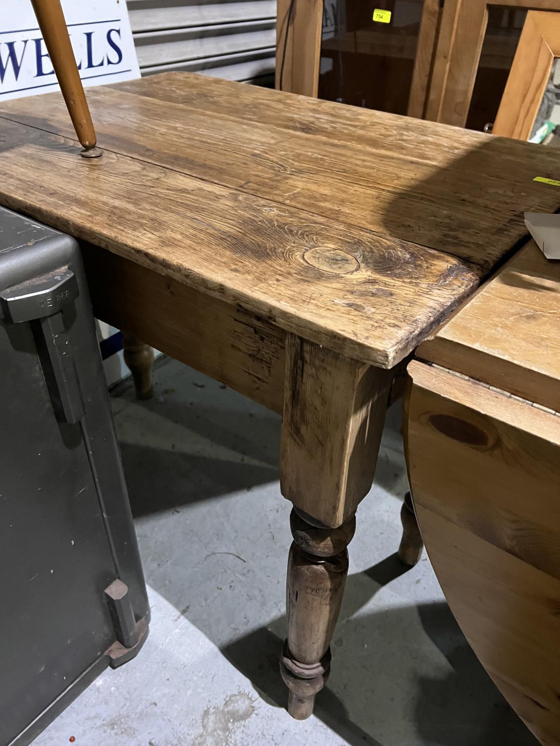 A Victorian stripped pine table with drawer and single drop leaf