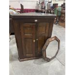 A 18th century oak corner cupboard, 37' high, together with an oak octagonal mirror with bevelled