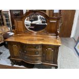 An early 20th century walnut bow-breakfronted sideboard with raised mirror back. 60' wide.