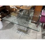 A modernist centre table, the glass top raised on a chrome plated slatted square base. 43' x 43'.