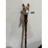 A walking stick, the carved fox head handle with glass eyes. 50' long