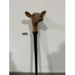 A hazel walking stick, the pommel hand carved as a fawn with glass eyes. 51' long