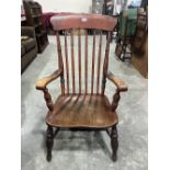 A Victorian stick back elbow chair with elm seat on splayed turned legs