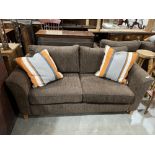 A two seater sofa upholstered in brown cord fabric with a pair of striped scatter cushions. 68'