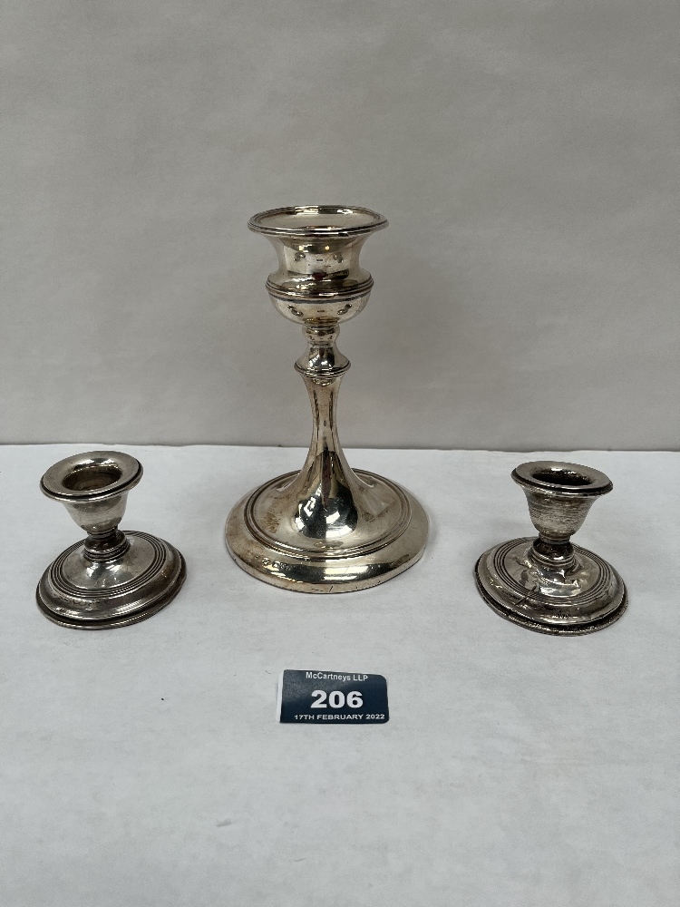 A George V silver loaded candlestick, Chester 1921, 5¾' high; together with a pair of silver