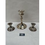 A George V silver loaded candlestick, Chester 1921, 5¾' high; together with a pair of silver