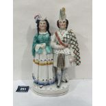 A 19th century Staffordshire Scotchman and lady companion group. 9' high