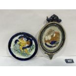 Two glazed pottery plaques decorated in relief with a putto on a dolphin and a lady. The oval