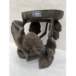 An African carved hardwood group of three figures. 14' high