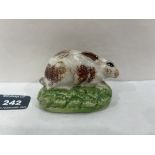A 19th century Staffordshire rabbit with sponged decoration in brown on a green base. 3' long