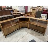 A 1950s corner bookcase in three sections, enclosed by glazed and blind doors