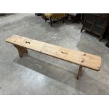 A pine bench with pierced top on shaped supports. 75' long