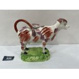 A 19th century Staffordshire pink lustre decorated cow creamer. 7¼' long