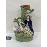 A 19th century Staffordshire girl and swan group spill vase. 8' high