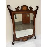 A mahogany and inlaid fret carved looking glass, the bevelled plate with re-entrant corners. 32'