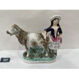 A 19th century Staffordshire cow and milkmaid creamer with painted and sponged decoration. 8' long
