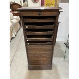 An oak filing cabinet enclosed by a tambour shutter. (A.F.)