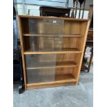 A bookcase enclosed by sliding glass doors. 36' wide