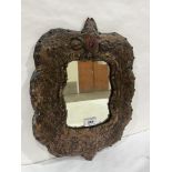 A 19th century mirror, the leather frame embossed with flowering foliage. 16' high