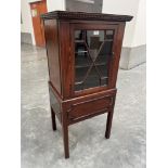 An early 20th century mahogany cabinet on stand enclosed by an astragal glazed door. 47' high.