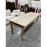 A Victorian pine farmhouse table, the plank top over a drawer at each end, raised on square legs.