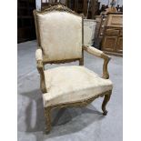 A late 19th century French carved giltwood and upholstered open armchair on cabriole legs with