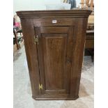 A George III oak hanging corner cupboard enclosed by a fielded panelled door. 44' high