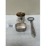 A Russian silver vodka measure, a silver napkin ring and a silver handled bottle opener