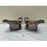A pair of 19th century plated helmet shaped sauce boats with vine fruit moulded rims and swan-neck