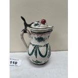 An 18th century sparrowbeak jug and cover (later hinged) painted with green swags and flowers, the