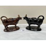 A Staffordshire Jackfield black glazed cow creamer. 7½' long and another in mottled treacle glaze 7'