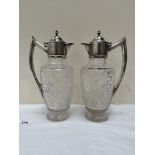 A pair of Edward VII cut glass claret jugs with silver mounts, handle and lid, raised on star cut