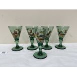 A set of five 19th century Bohemian green wine glasses, the funnel bowls painted in coloured enamels