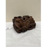 An oriental hardwood box, carved with serpents in high relief. 8' wide. Losses