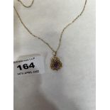 A gold openwork amethyst pendant on necklet chain marked 9ct. 3g gross