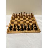 A chess set with turned wood pieces and wooden folding board, 17¾' x 17¾', with another chess set