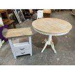 A painted and natural wood round pedestal table and a bedside chest with two drawers