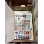 An album of postage stamps with a quantity of loose stamps