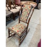 A Victorian beech rocking chair with upholstered back and seat