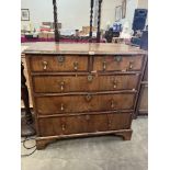 An 18th century walnut chest of two short over three long crossbanded drawers, raised on bracket