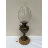 A brass oil lamp with moulded etched shade