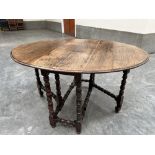 An antique joined oak dropleaf table on bobbin turned legs and perimeter stretchers. 44' wide