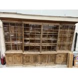 A 19th century pine breakfront library bookcase of country house proportions, enclosed by four