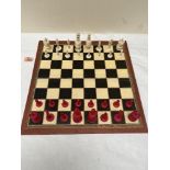 A red stained and natural bone chess set with board